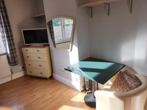 a small room with a table and a mirror at Southernwood - West Wing in Didcot
