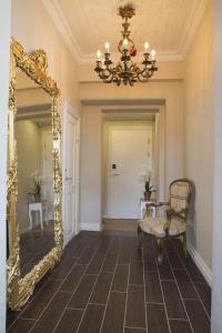 a hallway with a mirror and a chair and a chandelier at Sockerslottet Hotell in Kristinehamn
