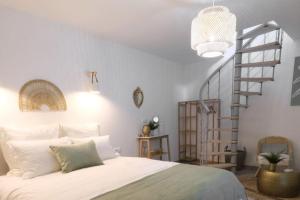 1 dormitorio con cama blanca y escalera de caracol en Lavilla dorée, en Moret-sur-Loing