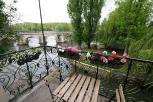a balcony with a bench and flowers and a bridge at Lavilla dorée in Moret-sur-Loing