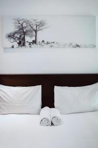 duas toalhas estão sentadas em cima de uma cama em City Apartments at Freedom Plaza em Windhoek