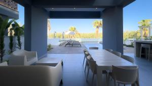a restaurant with tables and chairs and a patio at Sunrise Beachfront Villas - Villa 3 in Paralimni