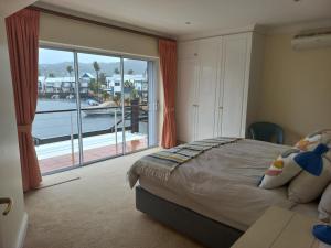 a bedroom with a large window with a view of a marina at 42 Spinnaker, The Quays in Knysna