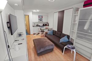 ein Wohnzimmer mit einem Sofa und einem Tisch in der Unterkunft Studio chaleureux avec vue sur les montagnes in Leukerbad