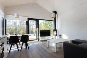 a living room with a table and chairs and a television at Himoskuutio 6 inc outdoor jacuzzi in Jämsä