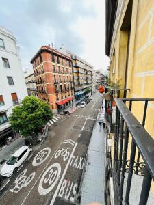 een uitzicht op een straat met auto's en gebouwen bij Hostal Abami II in Madrid