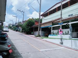 Ban Komo Sip Paet的住宿－PinkHomestayBetong(โฮมสเตย์เบตง)，一条空的街道,在建筑物前面停有一辆汽车