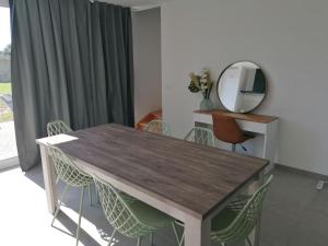 een eettafel met stoelen en een spiegel bij Rent & Relax: Vitrabelle in Lommel
