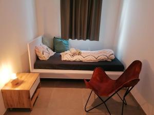 a room with a bed with a table and a chair at Rent & Relax: Vitrabelle in Lommel