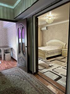 een kamer met een deur en een slaapkamer met een bed bij Квартира люкс in Taraz