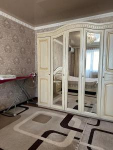 een kamer met een witte kast met glazen deuren bij Квартира люкс in Taraz