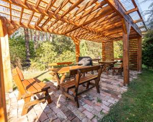 a patio with a wooden pergola and tables and chairs at Agroturystyka Nad Wartą in Skwierzyna