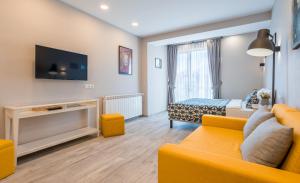 een woonkamer met een gele bank en een bed bij Lolo Apartment in Goedaoeri