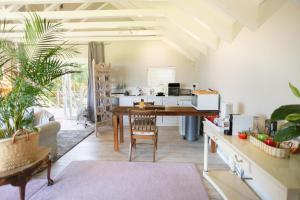 ein Wohnzimmer mit einem Tisch und einer Küche in der Unterkunft Protea & Pincushion Cottages in Hermanus