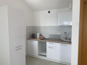 Una cocina blanca con gabinetes blancos y un fregadero. en DOM WAKACYJNY BEZPOŚREDNIO PRZY MORZu, en Sevid 23 fotos más