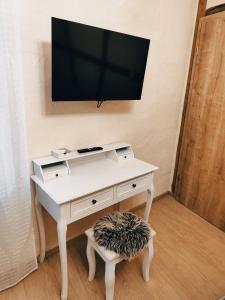 a white desk with a tv on a wall at Vintage-Design Ferienwohnung Florentine in Bad Klosterlausnitz