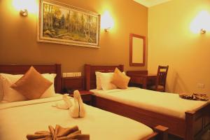 um quarto de hotel com duas camas e uma foto na parede em Chelsea Hotel em Dar es Salaam