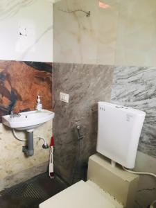 a bathroom with a toilet and a sink at Sana Estate Stay in Madikeri