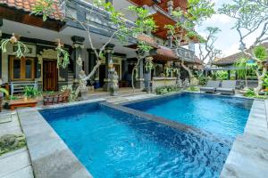a swimming pool in front of a house at Suarsena House Ubud in Ubud