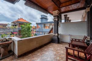 a balcony of a house with a table and chairs at Suarsena House Ubud in Ubud