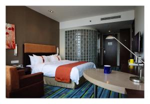 a hotel room with a large bed and a table at Holiday Inn Express Weihai Hi-Tech Zone, an IHG Hotel in Weihai