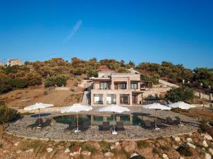 una vista aerea di una casa con piscina e ombrelloni di Borgo Thassos ad Astrís