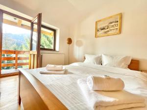 um quarto com uma grande cama branca e uma janela em Vila Titulescu em Sinaia