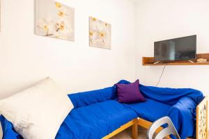 - un canapé bleu dans le salon doté d'une télévision dans l'établissement Massy & Alex house intero appartamento, à Rome