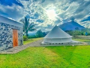 a white tent in a field next to a building at The Wes Village, incl Breakfast and Dinner in Chiang Dao