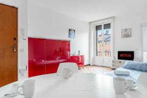 een woonkamer met een witte tafel en rode meubels bij MI8 -10 minutes from the Duomo- Large Apartment in Milaan