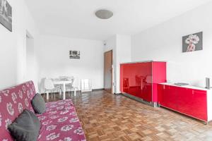 een woonkamer met een bank en een rode kast bij MI8 -10 minutes from the Duomo- Large Apartment in Milaan