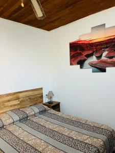 a bedroom with two beds and a painting on the wall at Pintadera house Caracola in Icod de los Vinos