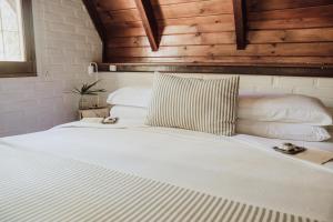 a bedroom with a white bed with pillows at Overo Lodge & Selva in Puerto Iguazú