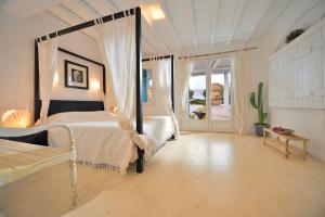 a bedroom with a bed and a large window at Villa Princess 5 4Bed with Jacuzzi Panormos Beach in Panormos Mykonos