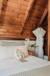 a bedroom with a white bed with wooden ceilings at Overo Lodge & Selva in Puerto Iguazú