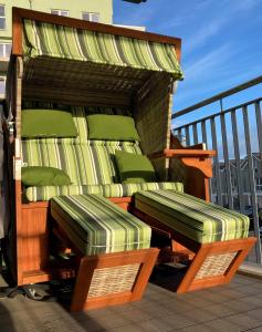 terraza de madera con sillas verdes en el balcón en 49 1 N Nordkoje, en Wangerland
