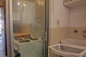 a small kitchen with a stove and a bath tub at Oceana Suites Terrazas del Faro in Punta del Este +11 photos