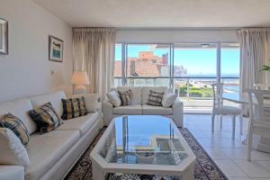 a living room with a couch and a table at Oceana Suites Terrazas del Faro in Punta del Este