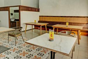 a room with tables and chairs and a kitchen at Capital O 1362 Ciliwung Guest House Syariah in Malang