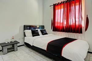 a bedroom with a bed and a red window at Capital O 1362 Ciliwung Guest House Syariah in Malang