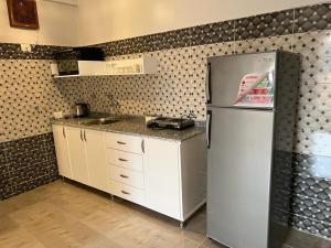 a kitchen with a refrigerator and a sink at Lemon Tree apartments luxor in Al Aqālitah