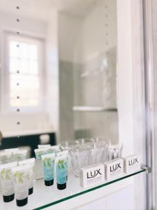 a shelf with glasses and bottles of lox lux on it at The Western in St Ives