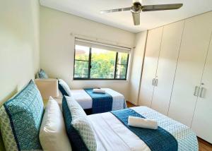 a small room with two beds and a window at Luxury Waterfront Apartment (2 bedrooms) in Darwin