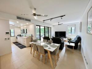 a kitchen and a living room with a table and chairs at Luxury Waterfront Apartment (2 bedrooms) in Darwin