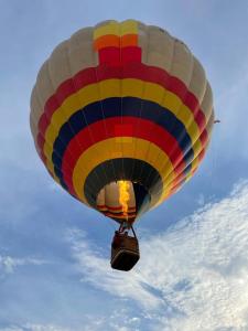 a colorful hot air balloon flying in the sky at NEW Cosy cottage - Lake view & Log Burner - Dog proof garden in Rolvenden