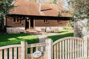 a wooden fence in front of a house at NEW Cosy cottage - Lake view & Log Burner - Dog proof garden in Rolvenden