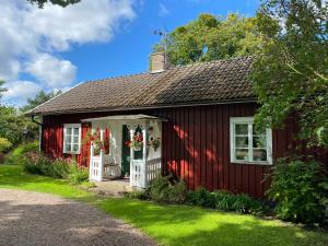 a red house with flowers on the door at Stenbrottets lillstuga in Falköping