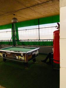 a pool table in a room with a green wall at Urban Escape in Nairobi