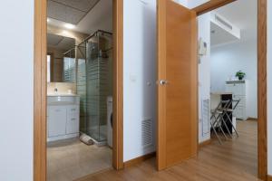 bagno con porta a vetri che conduce a una cucina di FiveStepsToSea - Beach Apartment Valencia a Valencia