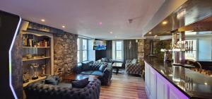 a living room with a bar with couches and a table at The Birchtree Hotel in Dalbeattie